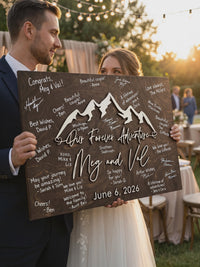 Bride and groom holding the signed Our Forever Adventure mountain guest book sign in Jacobean stain.