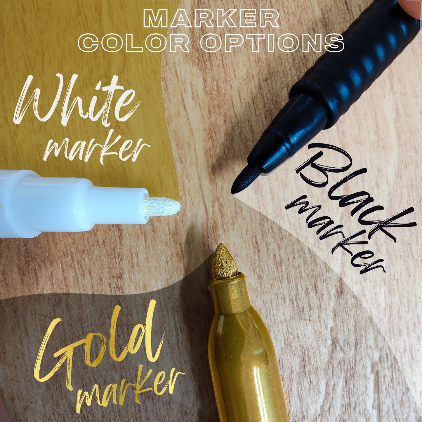 Three markers with white, black, and gold color options on a wooden surface.