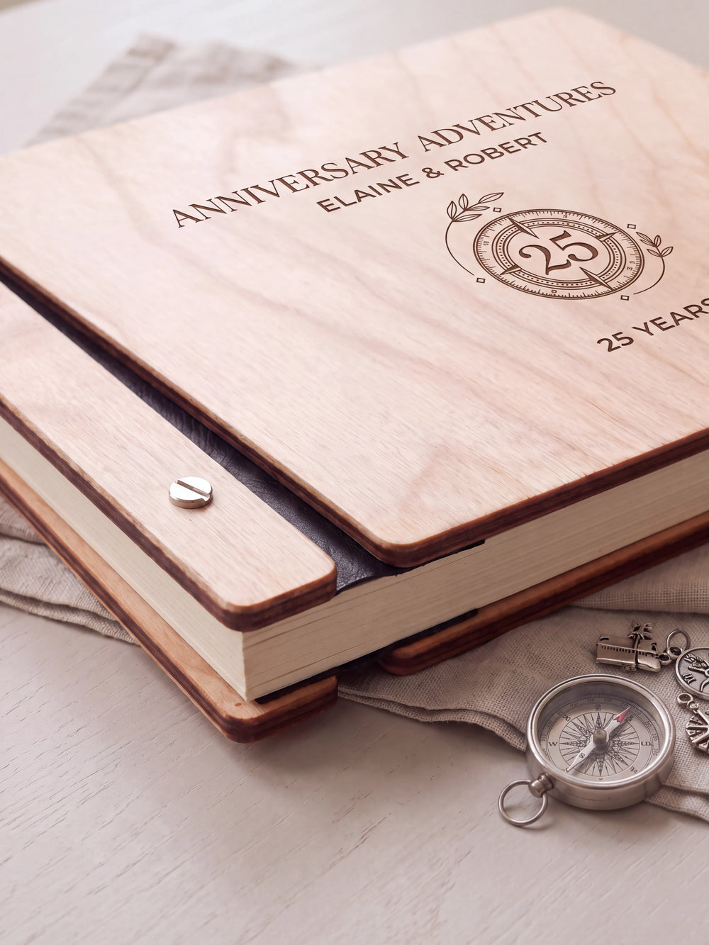 Close-up of the Natural wooden album binding: a polished silver slotted screw, black flexible hinge, separate wooden cover pieces and cream page edges.