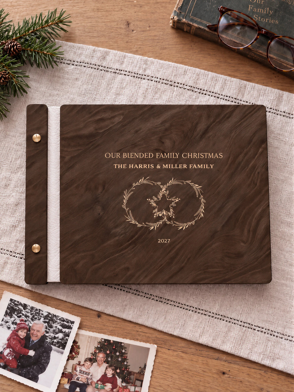Jacobean wooden album with cream laser engraving of two intertwined festive wreaths. The full personalized cover rests on a styled surface, with ivory binding and gold screws.
