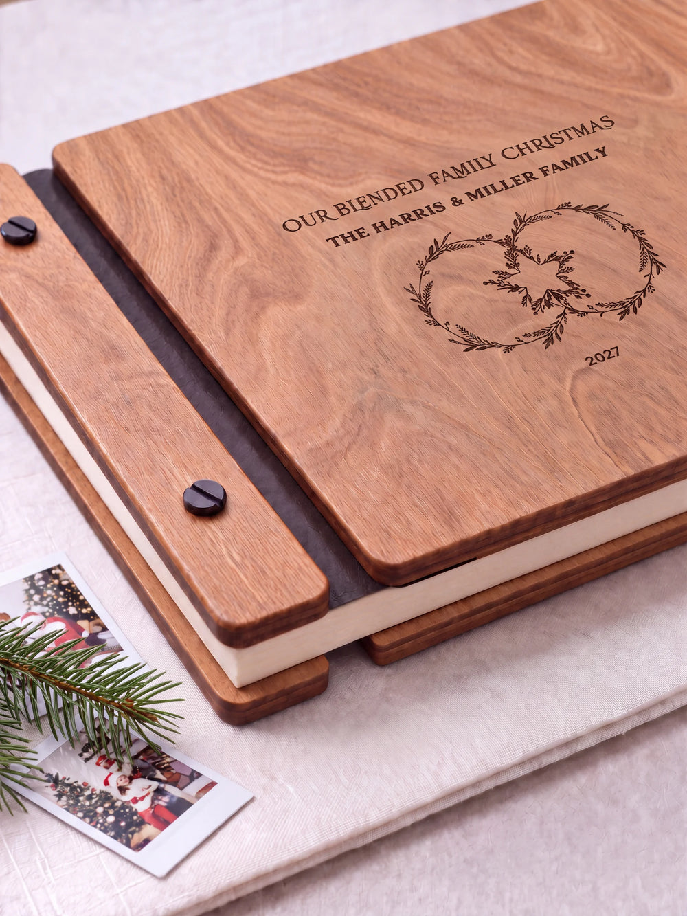 Close view of the Hazelnut album’s brown engraving, binding and black screw heads. Cream page edges and separate wooden cover sections are visible.