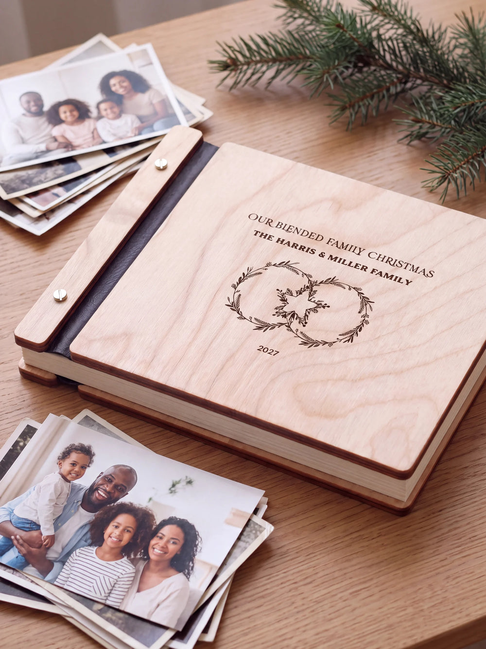 Close view of a Natural wood album with brown engraving, black binding and silver screw heads. The cream page edges and divided wooden cover construction are visible.