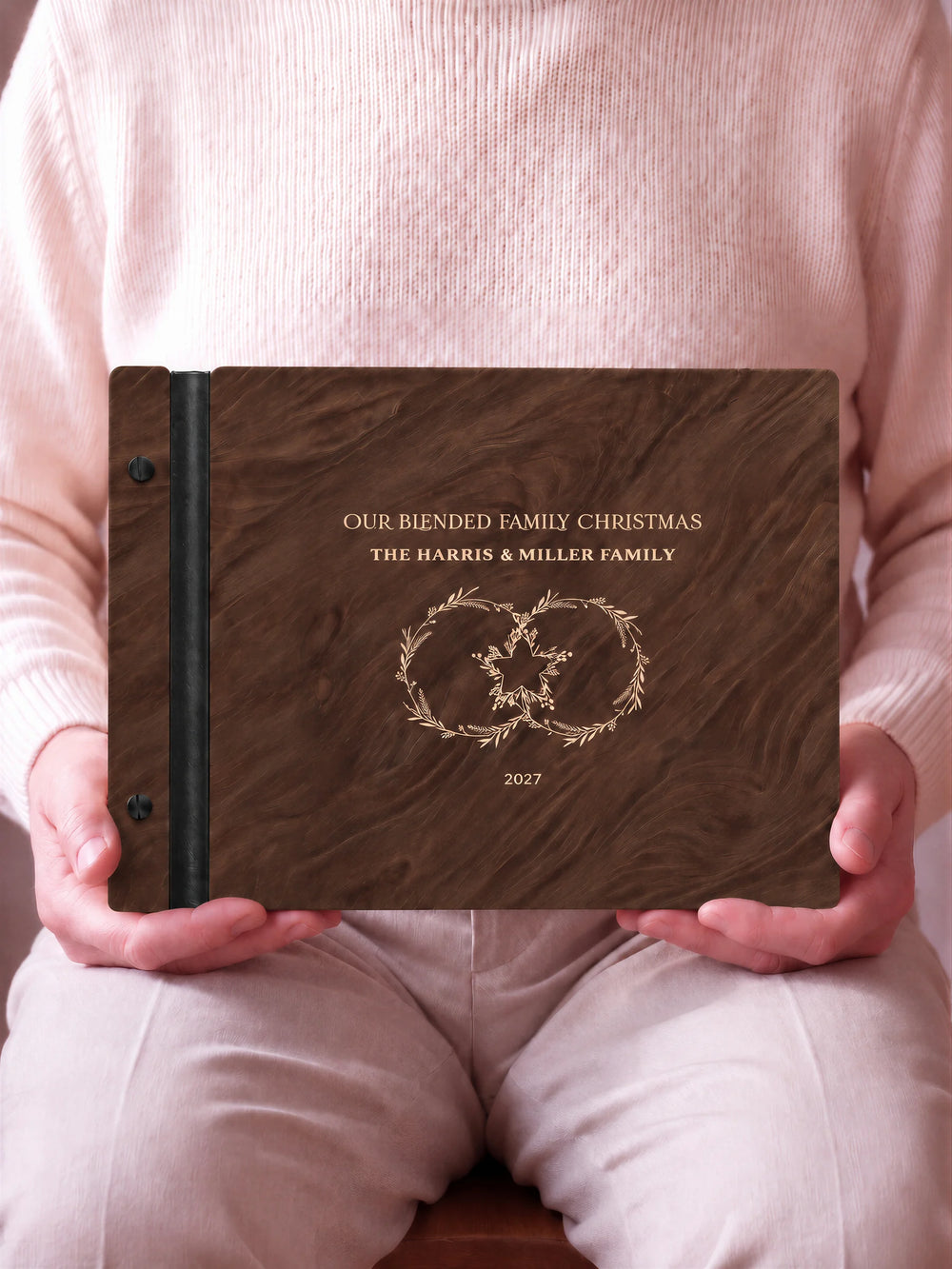 A close view of the dark brown Jacobean album and its cream laser-engraved OUR BLENDED FAMILY CHRISTMAS design, with black binding and matte black screws.