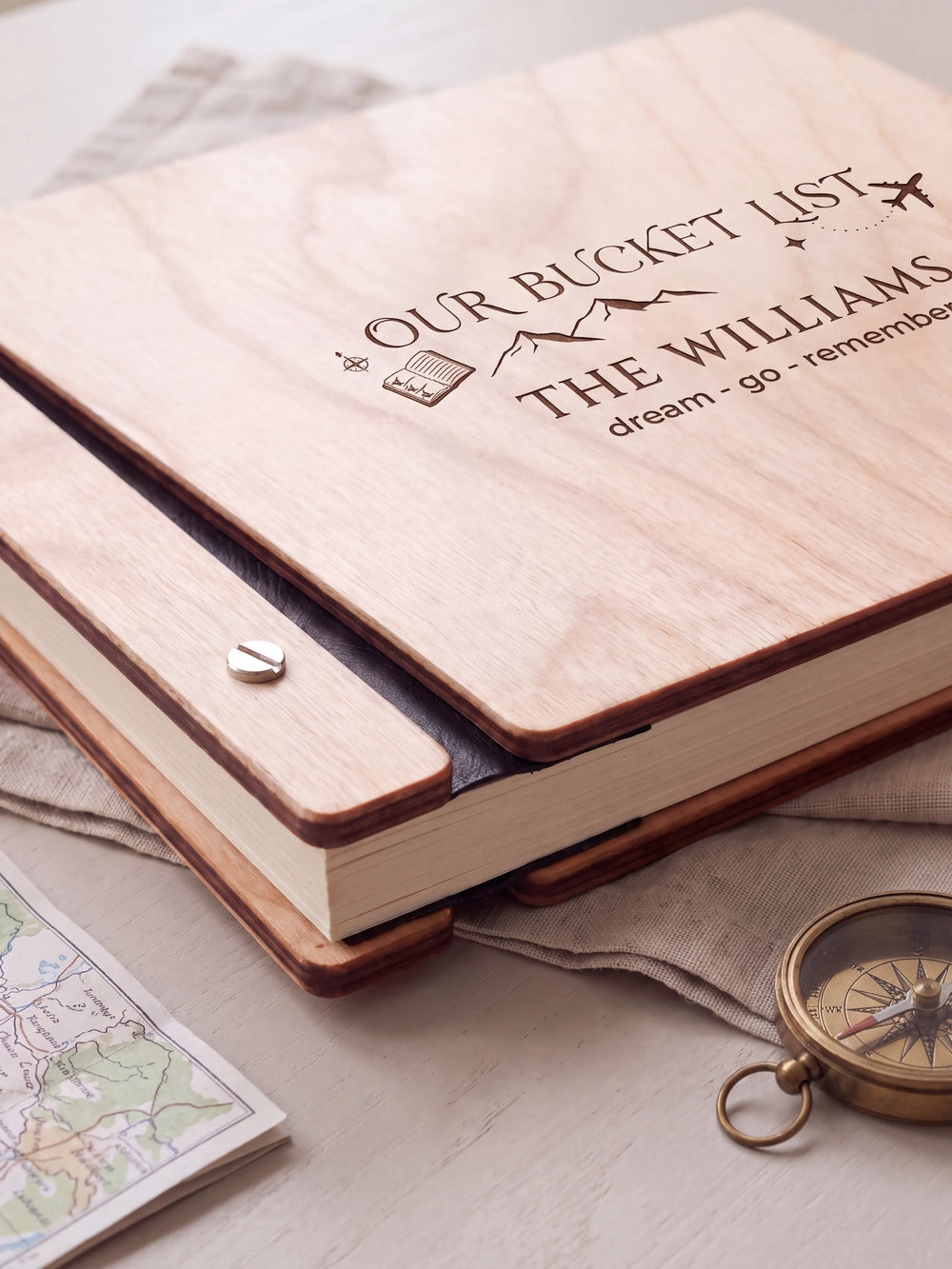 Close-up of the Natural wooden album binding: a polished silver slotted screw, black flexible hinge, separate wooden cover pieces and cream page edges.