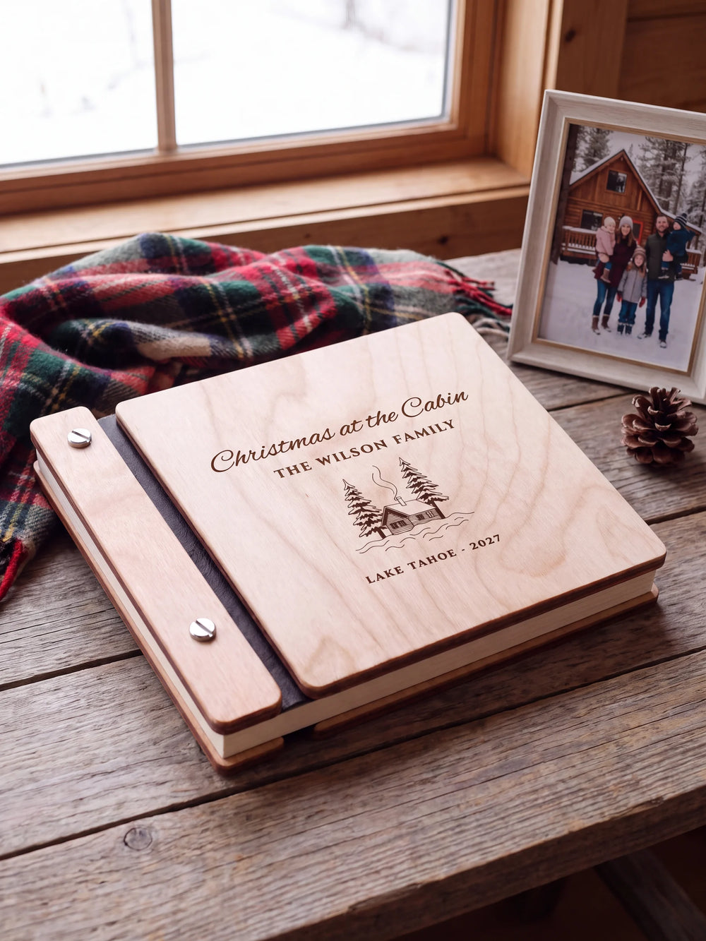 Close view of a Natural wood album with brown engraving, black binding and silver screw heads. The cream page edges and divided wooden cover construction are visible.