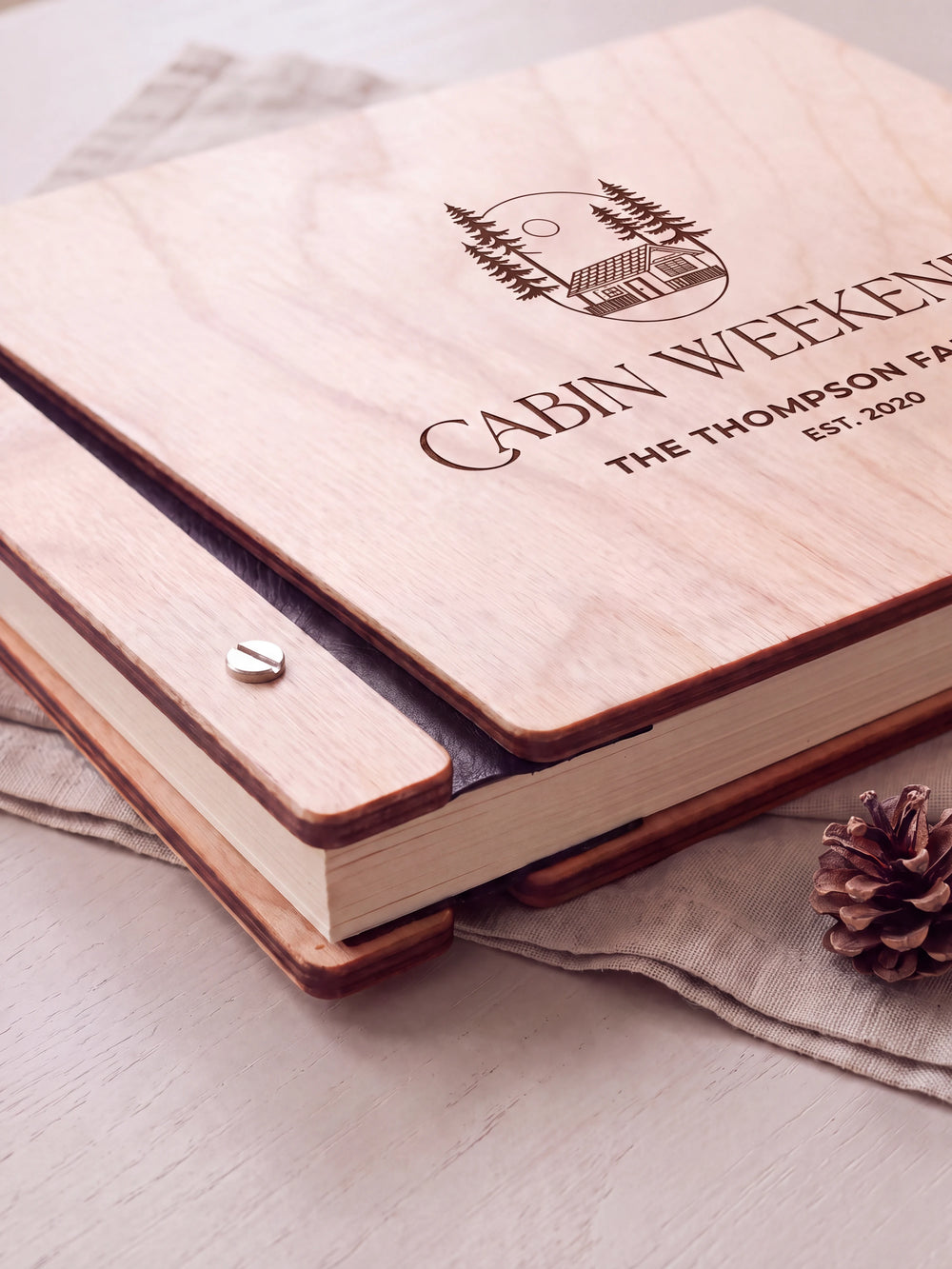 Close-up of the Natural wooden album binding: a polished silver slotted screw, black flexible hinge, separate wooden cover pieces and cream page edges.