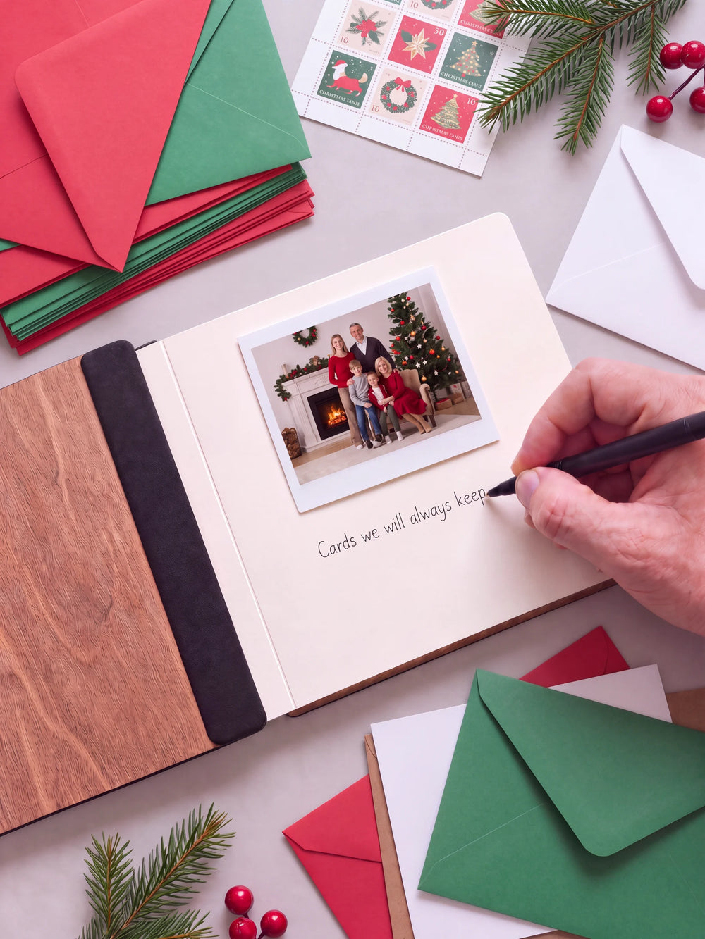 An open Hazelnut album with a photograph on a cream page. A hand writes a memory beneath it; a flat black fabric strip runs along the inner wooden cover.