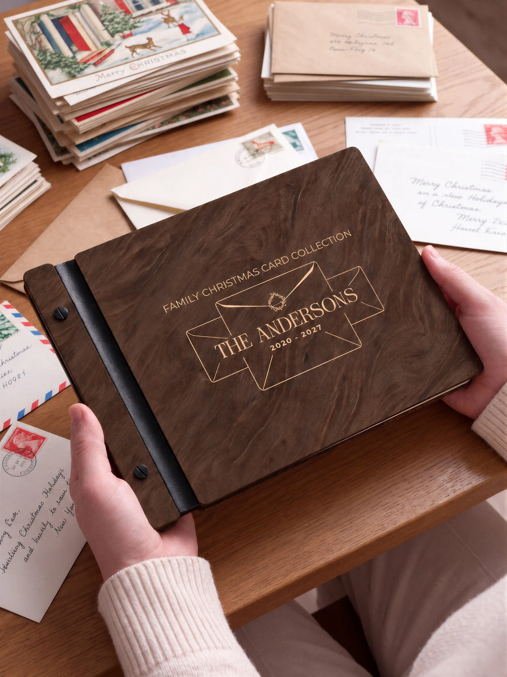 A close view of the dark brown Jacobean album and its cream laser-engraved FAMILY CHRISTMAS CARD COLLECTION design, with black binding and matte black screws.