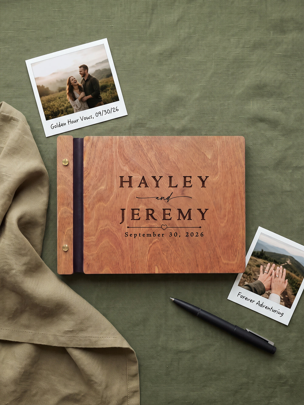 Hazelnut wood wedding photo guest book engraved Hayley and Jeremy September 30, 2026 with a small heart, on green fabric with instant photos and a pen