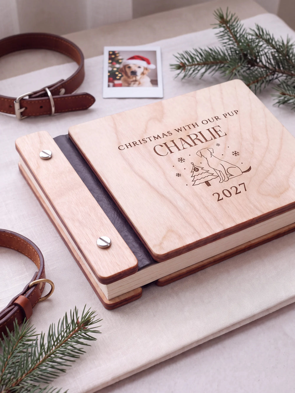 Close view of a Natural wood album with brown engraving, black binding and silver screw heads. The cream page edges and divided wooden cover construction are visible.