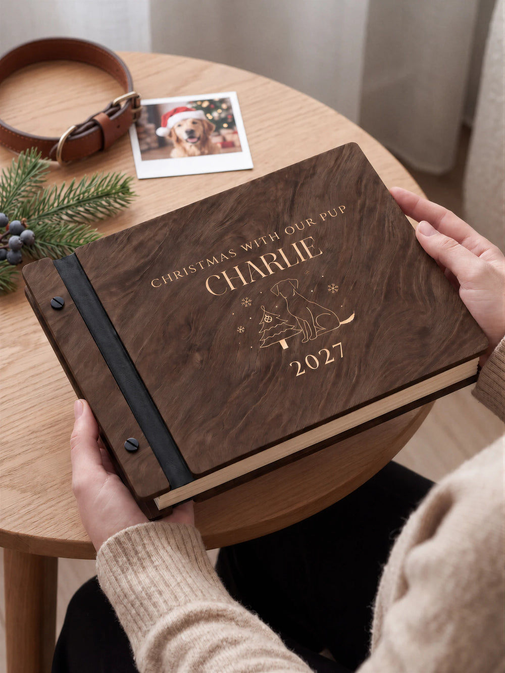 A close view of the dark brown Jacobean album and its cream laser-engraved CHRISTMAS WITH OUR PUP design, with black binding and matte black screws.