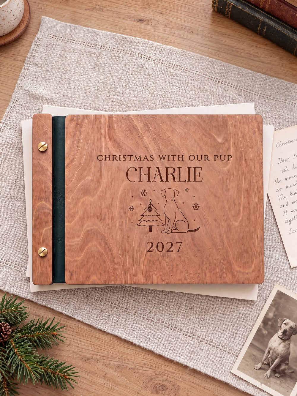 The full Hazelnut CHRISTMAS WITH OUR PUP album cover is shown close up. Brown engraved artwork, personalized wording, the narrow binding and gold screws are visible.