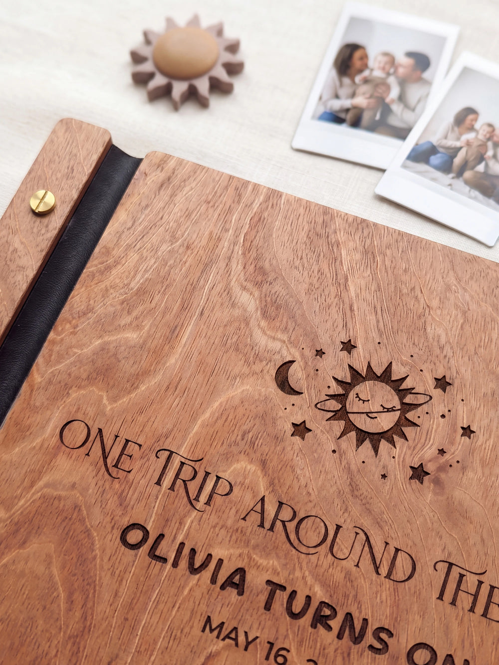 Close-up of the laser engraving on Hazelnut wood: a smiling sun with a crescent moon and stars and the personalized text against the visible wood grain