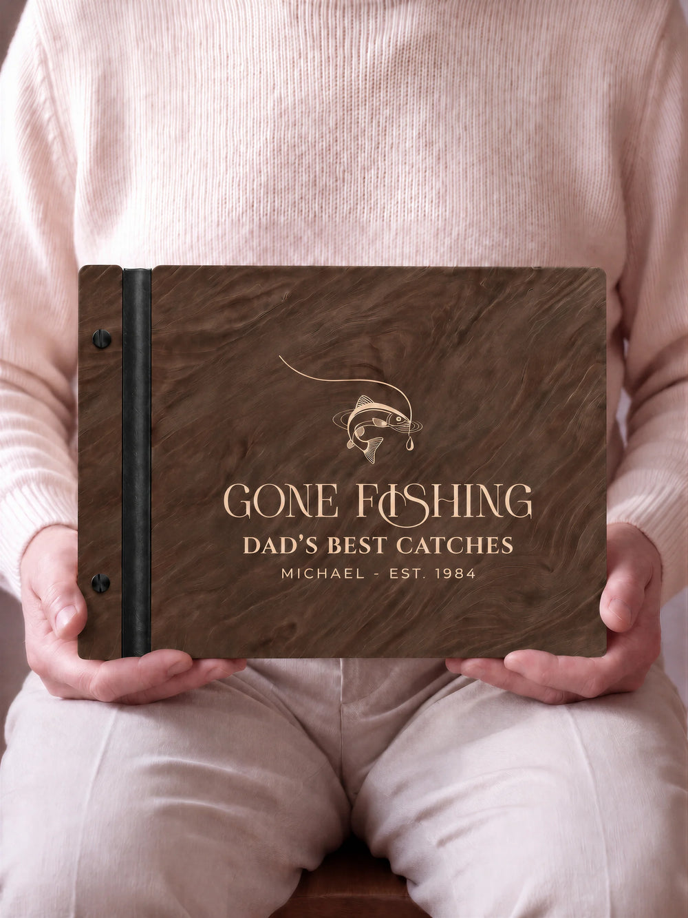 A close view of the dark brown Jacobean album and its cream laser-engraved GONE FISHING design, with black binding and matte black screws.