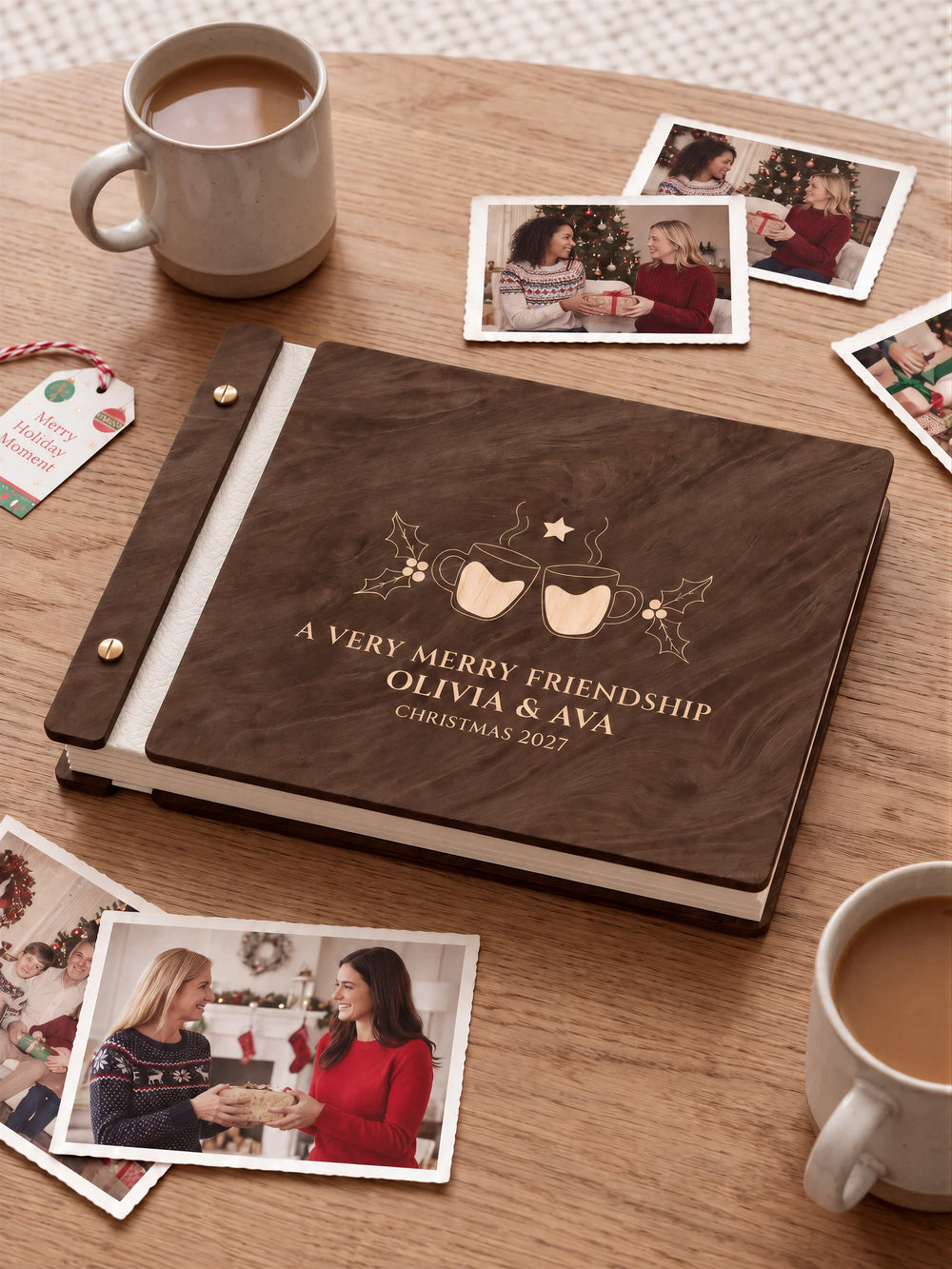 Jacobean wooden album with cream laser engraving of two steaming mugs with heart centers and holly. The full personalized cover rests on a styled surface, with ivory binding and gold screws.