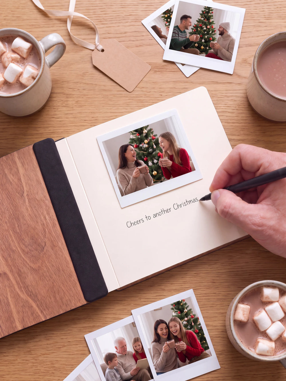 An open Hazelnut album with a photograph on a cream page. A hand writes a memory beneath it; a flat black fabric strip runs along the inner wooden cover.