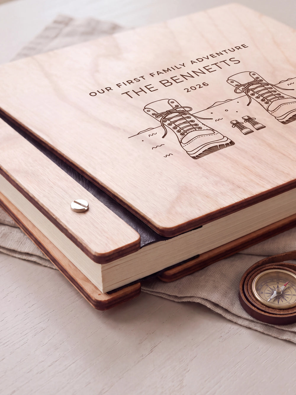Close-up of the Natural wooden album binding: a polished silver slotted screw, black flexible hinge, separate wooden cover pieces and cream page edges.