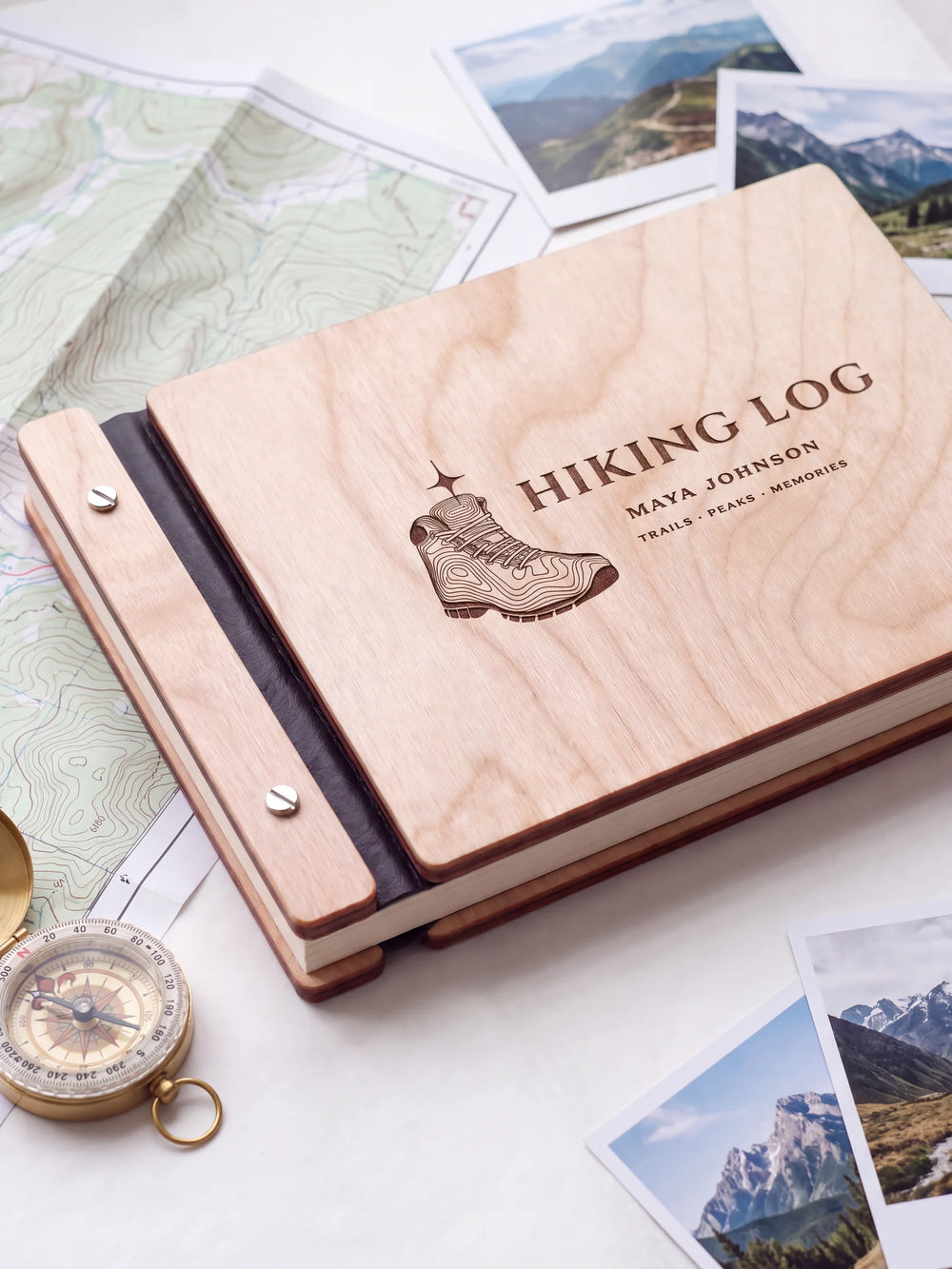 Close view of a Natural wood album with brown engraving, black binding and silver screw heads. The cream page edges and divided wooden cover construction are visible.