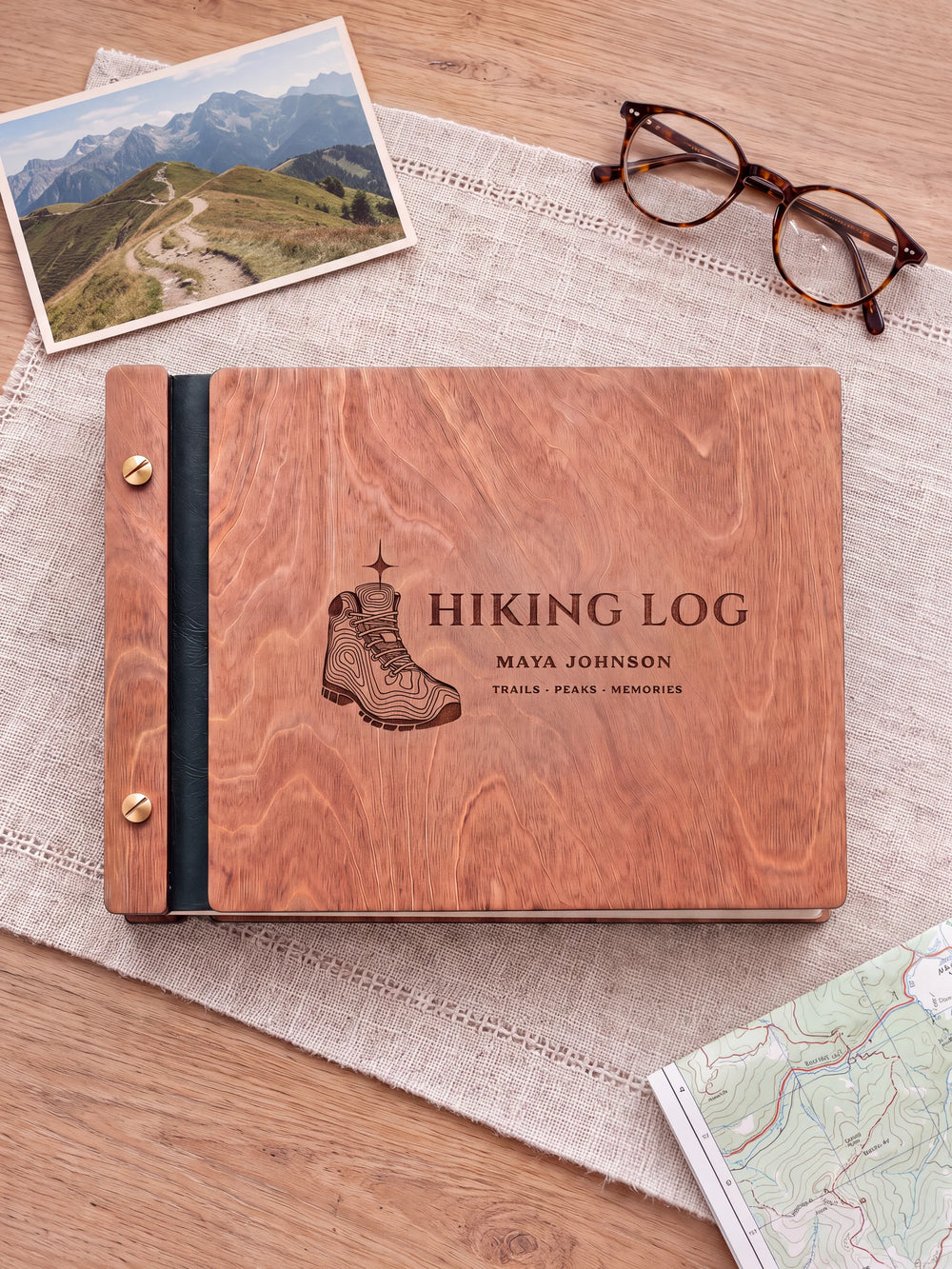 The full Hazelnut HIKING LOG album cover is shown close up. Brown engraved artwork, personalized wording, the narrow binding and gold screws are visible.