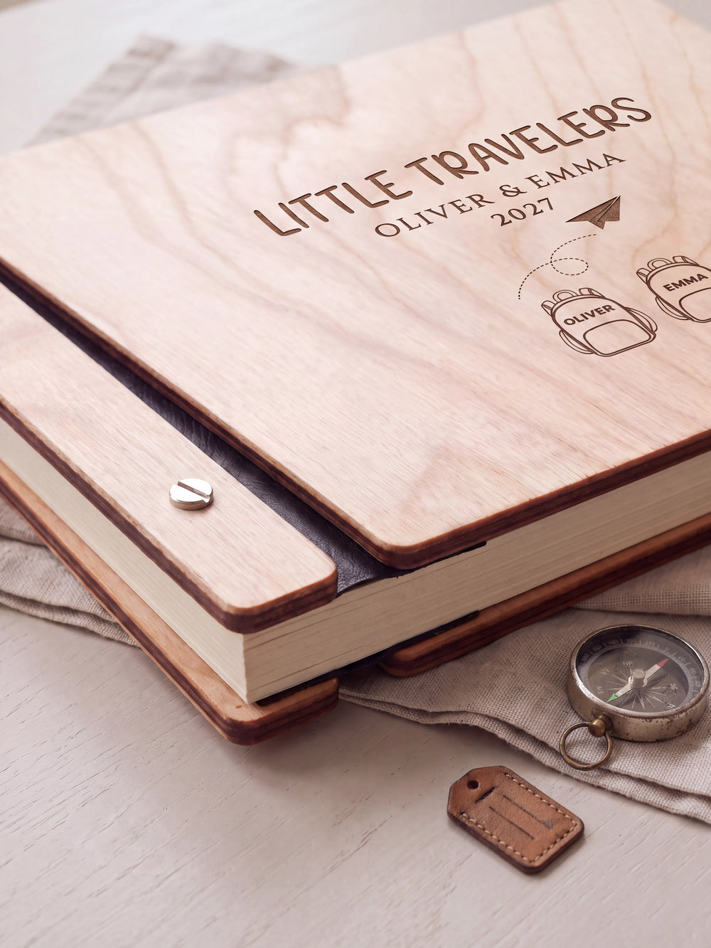 Close-up of the Natural wooden album binding: a polished silver slotted screw, black flexible hinge, separate wooden cover pieces and cream page edges.