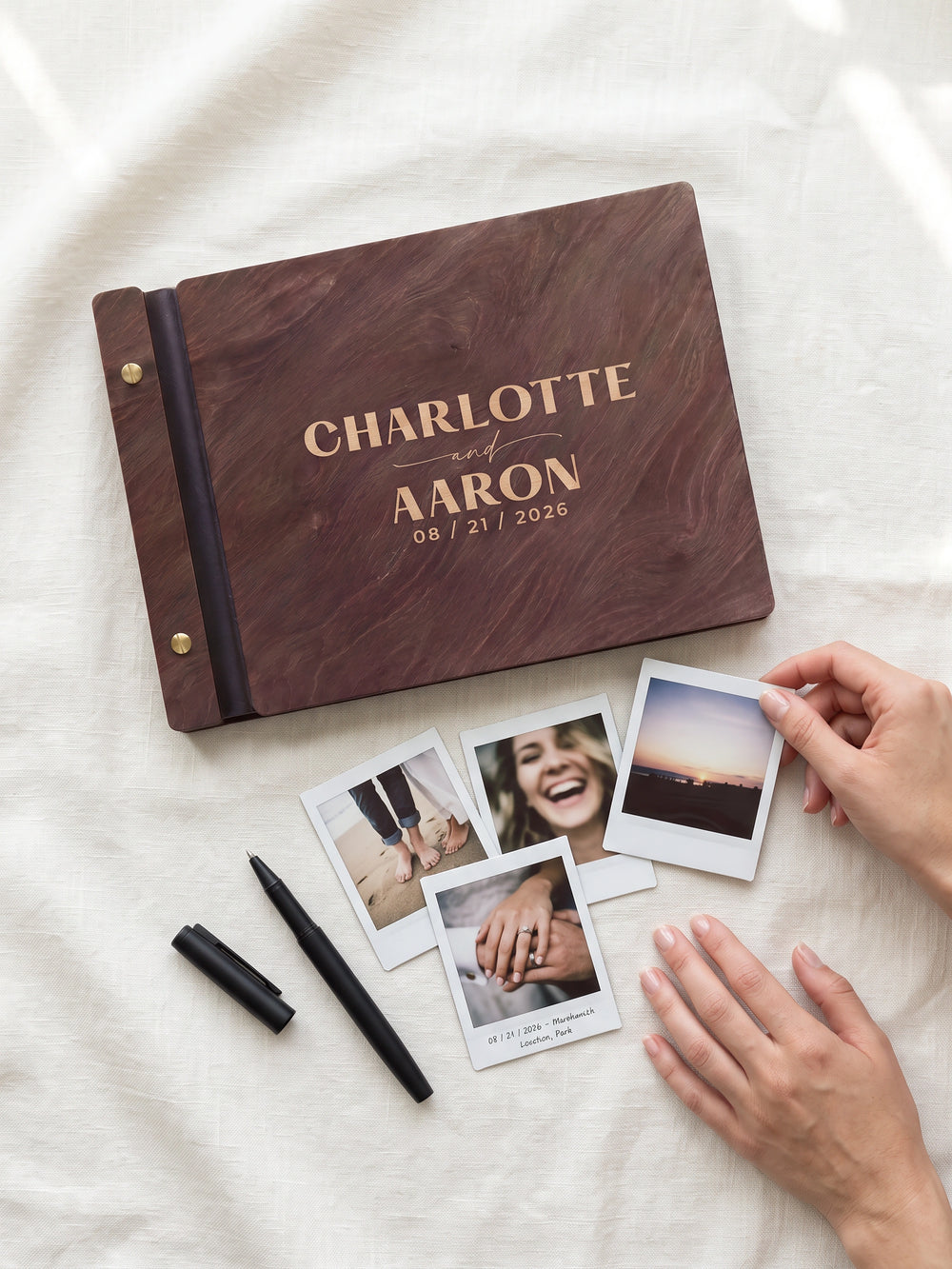 Jacobean wood Charlotte and Aaron photo guest book on white linen with four instant photos and a black pen