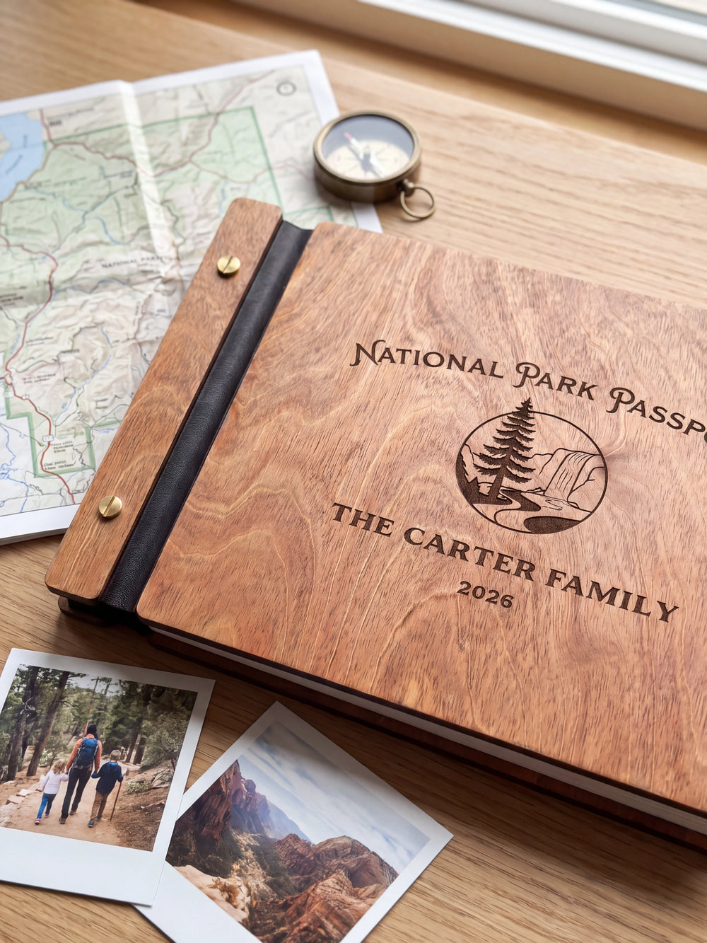 Close-up of a pine tree and rocky park landscape engraved in dark brown on the Hazelnut wooden cover, showing the fine artwork and surrounding wood grain.