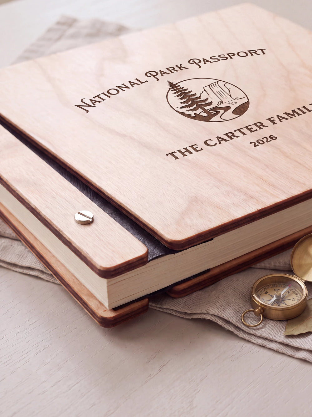 Close-up of the Natural wooden album binding: a polished silver slotted screw, black flexible hinge, separate wooden cover pieces and cream page edges.