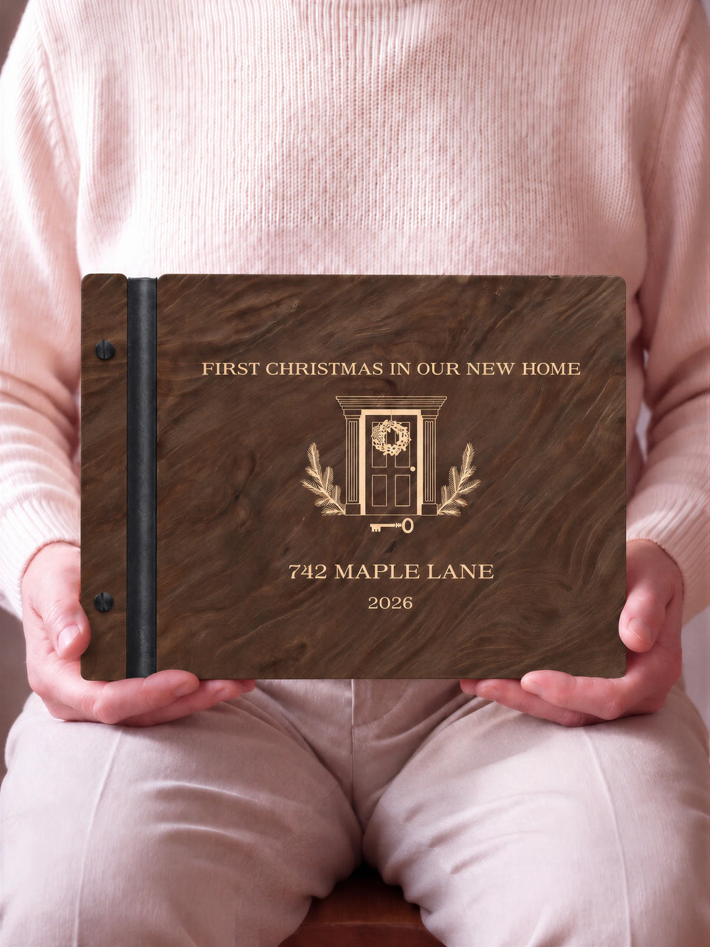 A close view of the dark brown Jacobean album and its cream laser-engraved FIRST CHRISTMAS IN OUR NEW HOME design, with black binding and matte black screws.