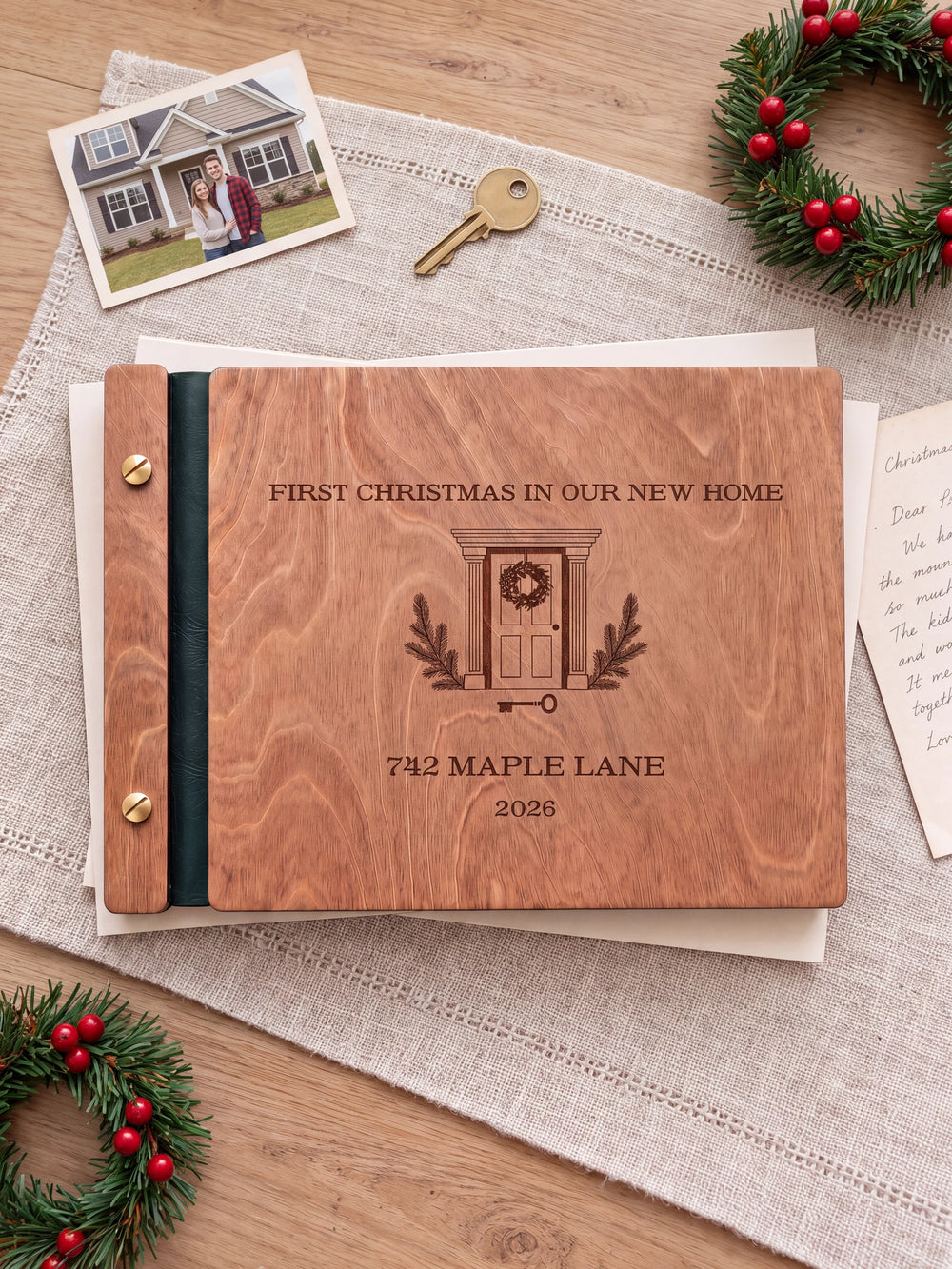 The full Hazelnut FIRST CHRISTMAS IN OUR NEW HOME album cover is shown close up. Brown engraved artwork, personalized wording, the narrow binding and gold screws are visible.
