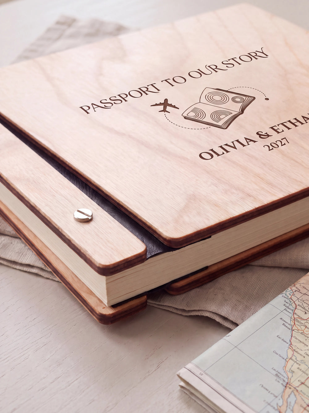 Close-up of the Natural wooden album binding: a polished silver slotted screw, black flexible hinge, separate wooden cover pieces and cream page edges.