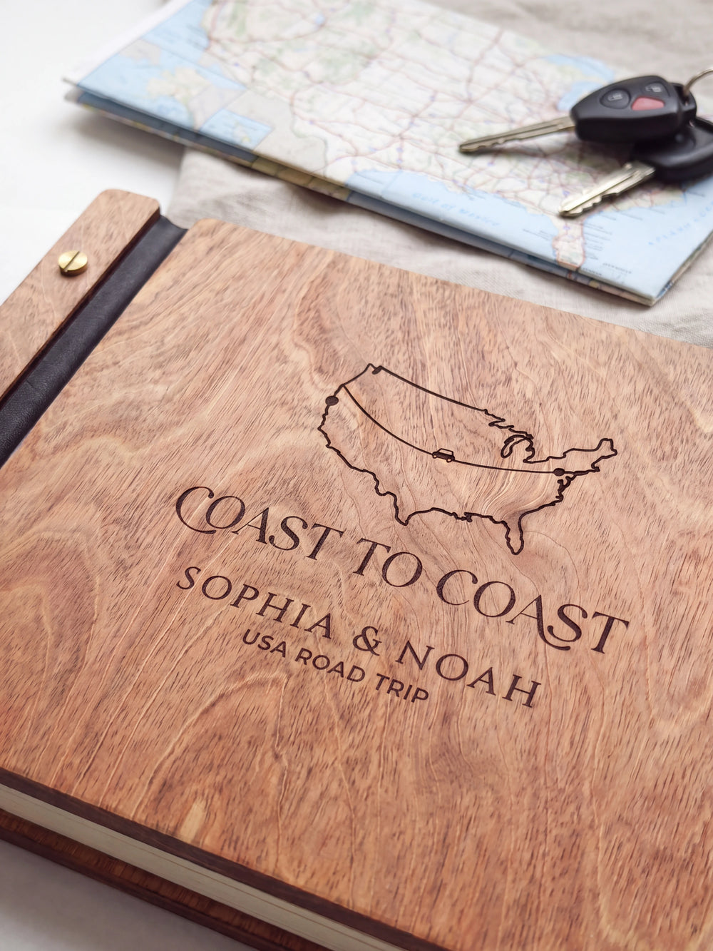 Close-up of a USA outline map and road-trip route engraved in dark brown on the Hazelnut wooden cover, showing the fine artwork and surrounding wood grain.