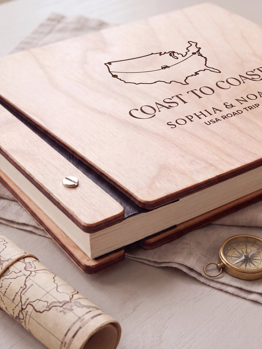 Close-up of the Natural wooden album binding: a polished silver slotted screw, black flexible hinge, separate wooden cover pieces and cream page edges.