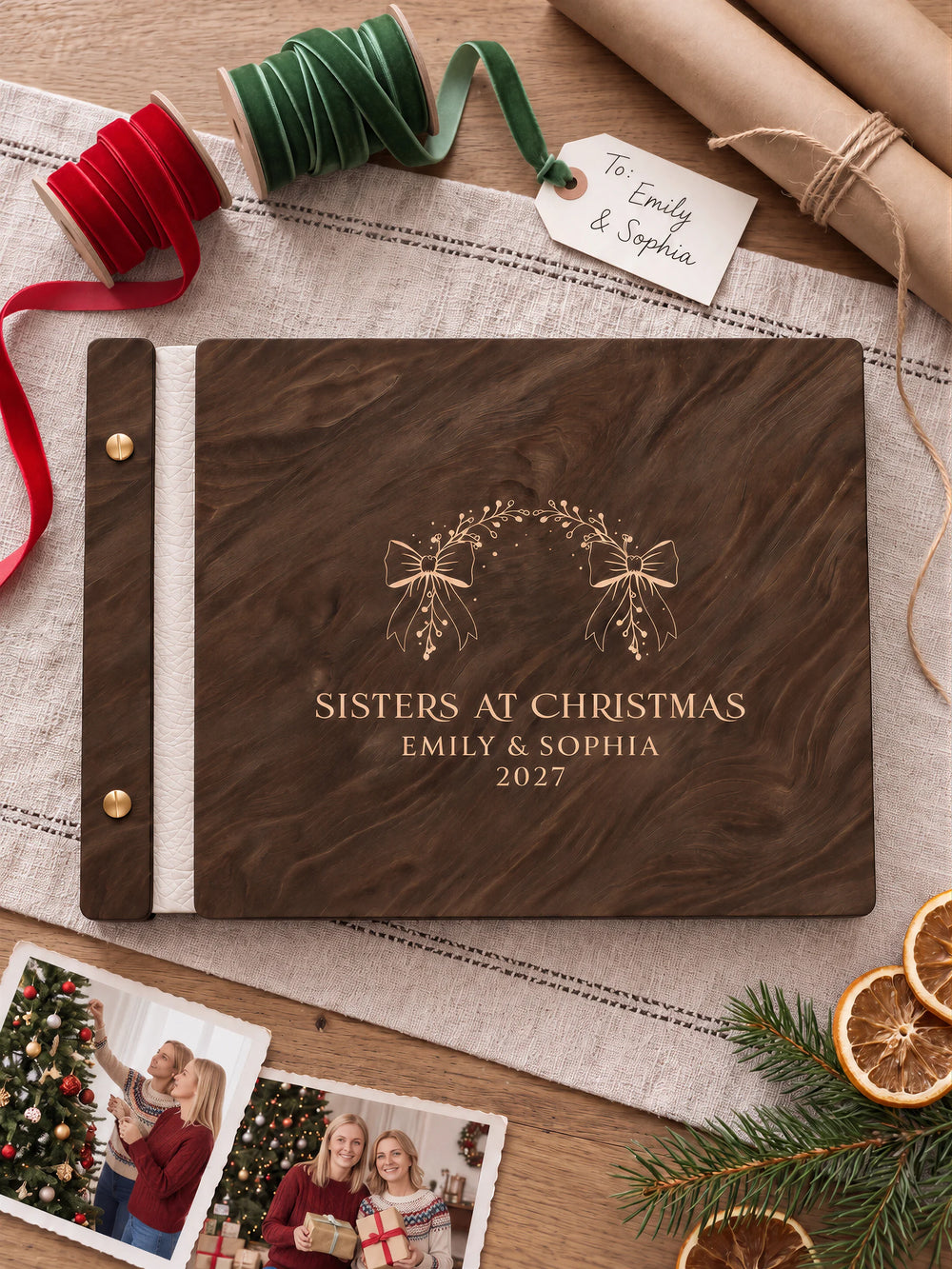 Jacobean wooden album with cream laser engraving of bow-tied evergreen arch. The full personalized cover rests on a styled surface, with ivory binding and gold screws.