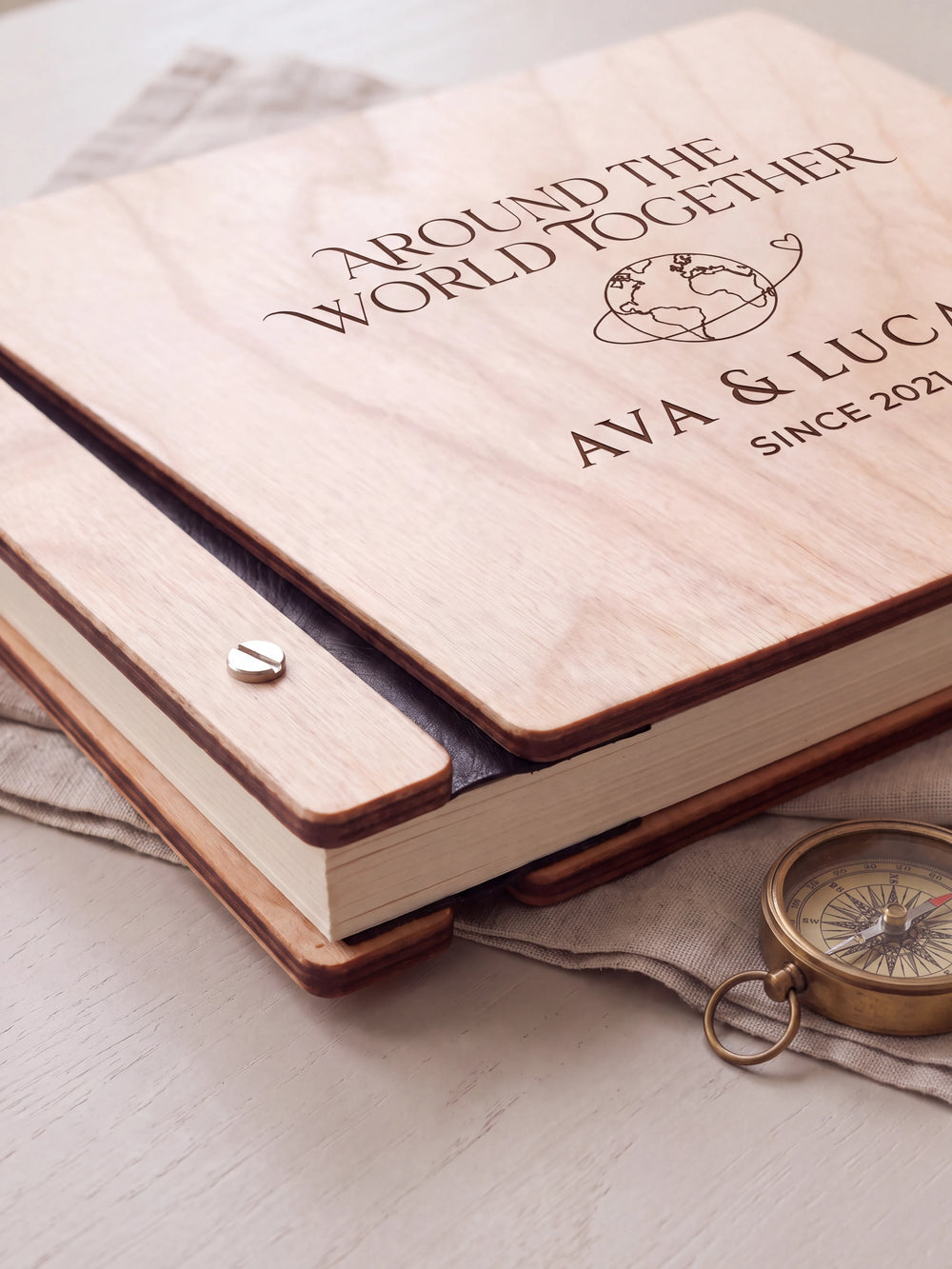 Close-up of the Natural wooden album binding: a polished silver slotted screw, black flexible hinge, separate wooden cover pieces and cream page edges.