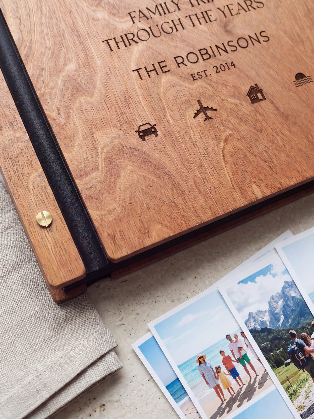 Close-up of small travel symbols engraved in dark brown on the Hazelnut wooden cover, showing the fine artwork and surrounding wood grain.