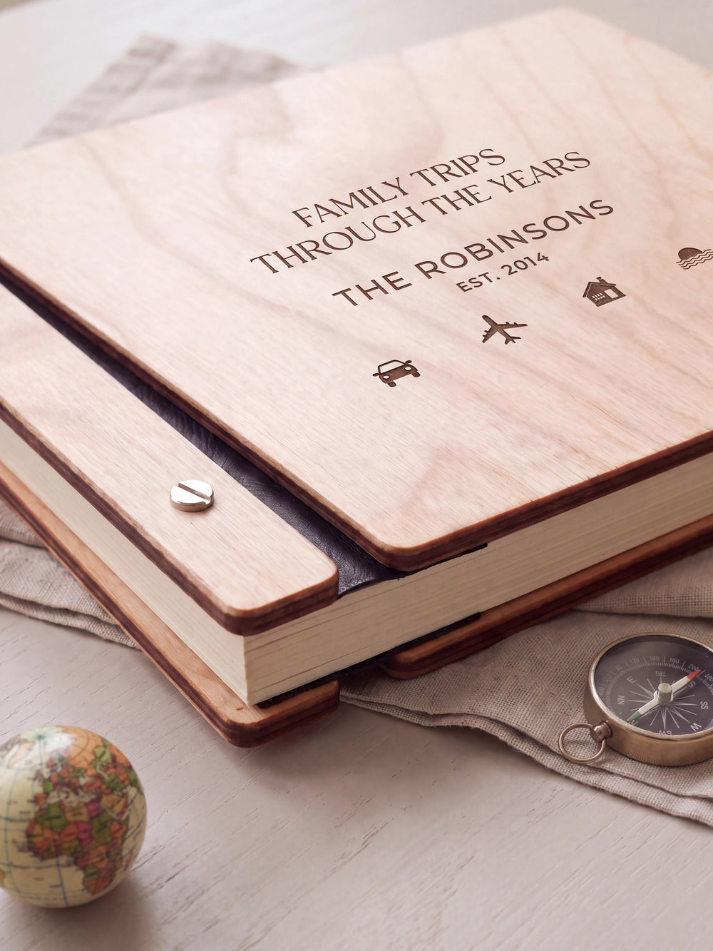 Close-up of the Natural wooden album binding: a polished silver slotted screw, black flexible hinge, separate wooden cover pieces and cream page edges.