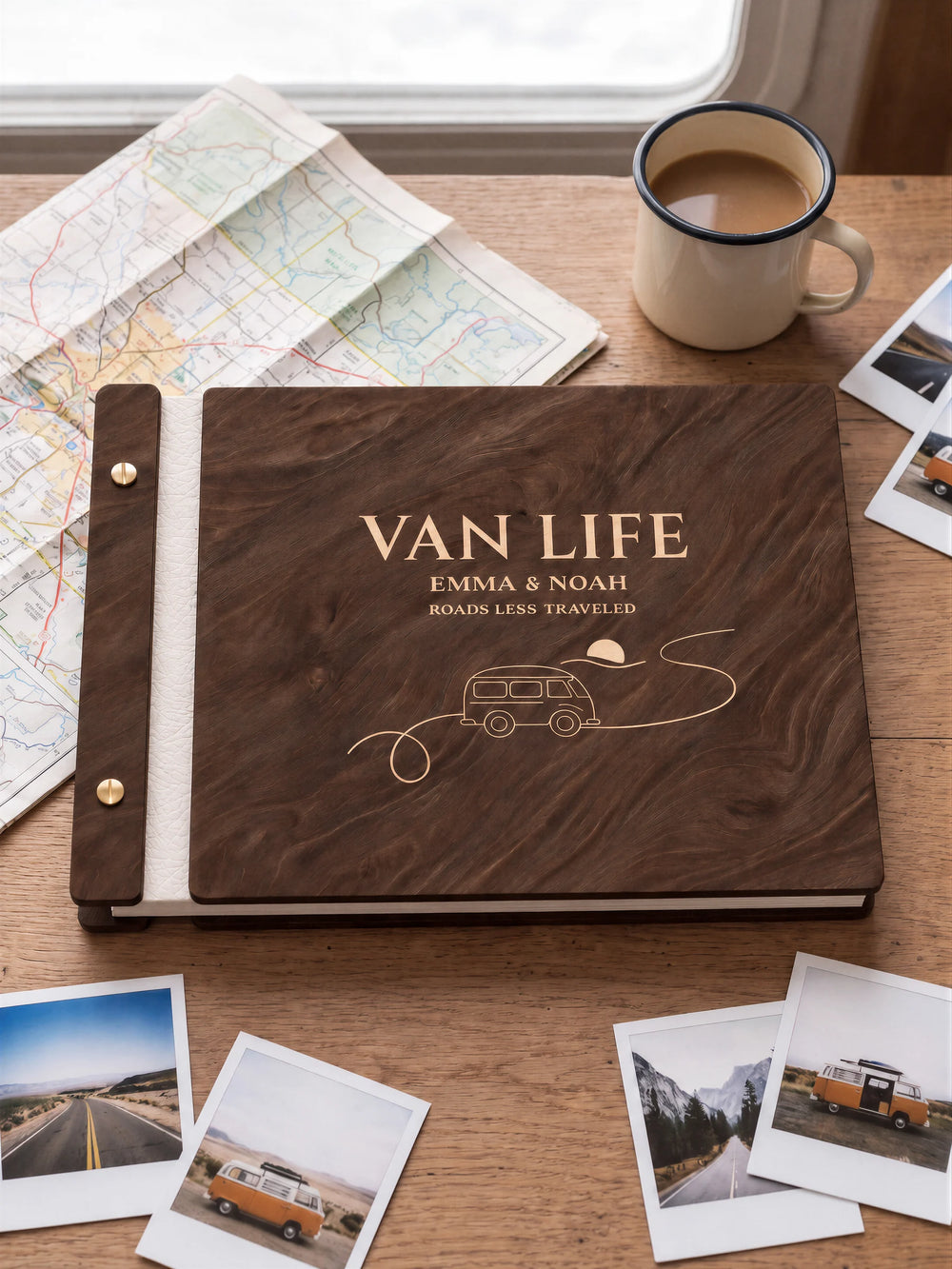 Jacobean wooden album with cream laser engraving of camper van, winding road and sun. The full personalized cover rests on a styled surface, with ivory binding and gold screws.